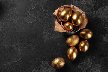 Golden Easter eggs on a black concrete background