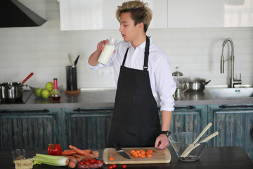 Asian cook in the kitchen prepares food in a cook suit