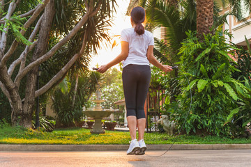 Obraz premium Woman doing exercises with jumping rope at home.