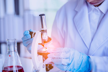 Female scientist look at microscope, science test tube analyse scientific sample in laboratory...