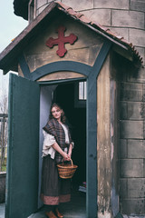 Portrait of a woman in medieval dress at the door of an old European Church, clothes on Halloween 18-19th century