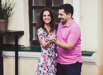 young cheerful couple hugging on the streets of the city
