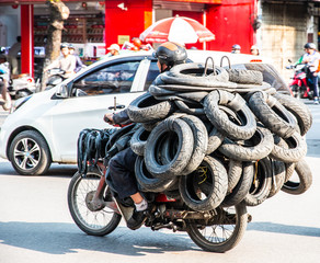 Vietnamese driving a motorbike and transporting a lot of packages. This is a typical vietnam...