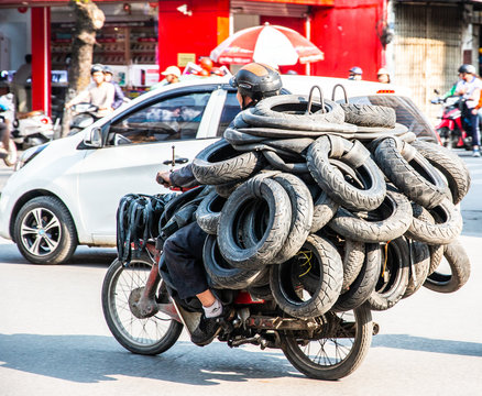 Vietnamese driving a motorbike and transporting a lot of packages. This is a typical vietnam transport with motorcycle or scooter
