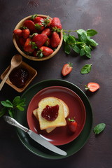 Toasts with strawberry jam for breakfast, rustic style 