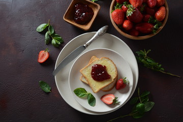 Toasts with strawberry jam for breakfast, rustic style 