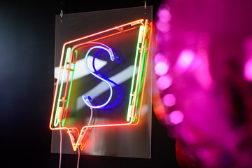 Colorful balloons and neon symbol  on the black photo zone.