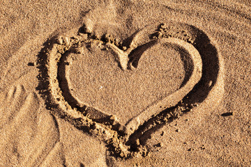 Background of wet sand, heart made of sand, beach sand.