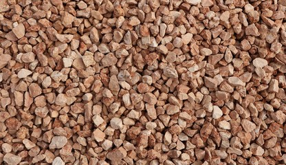 Decorative gravel of red pebbles used in garden or backyard. Background and texture