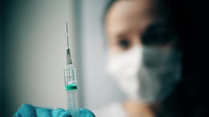 Dripping syringe against blurred woman face, slow motion shot - Powered by Adobe