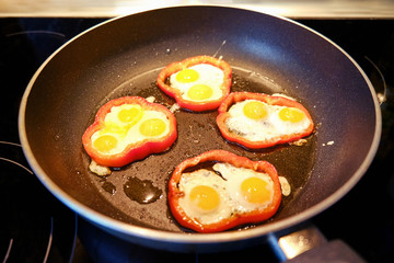 Scrambled quail eggs fried on the kitchen stove in chopped bell pepper