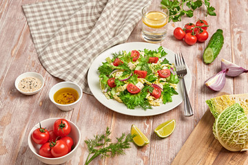 Fresh salad with cherry tomatoes, savoy cabbage, cucumeber on dish. Healthy summer salad vegetarian meal concept. Tasty mixed leaves, tomatoes and mix vegetable salad on wood background