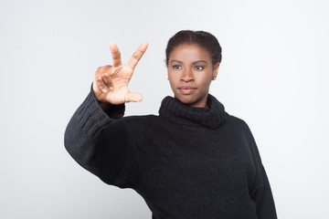 Front view of calm woman using virtual screen. Attractive young lady pressing something on imaginary screen. Virtual screen concept