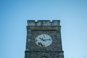 A Clock Tower on a Cobblestone Tower in a Blue Sky