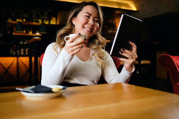 Close up of a Beautiful Asian woman looking at her tablet	