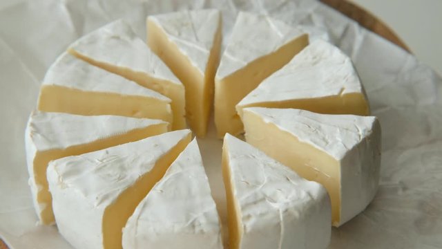 Sliced sectors of soft cheese brie or camambert rotating, close up