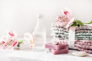 Obraz na płótnie Canvas natural soap. handmade soap with a bottle of oil. Stack of fresh towels with flowers on a white background. spa treatments.