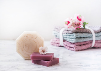 natural soap. handmade soap with a bottle of oil. Stack of fresh towels with flowers on white background. spa treatments