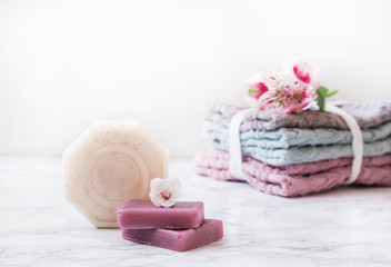 Fototapeta na wymiar natural soap. handmade soap. Stack of fresh towels with flowers on white background. spa treatments