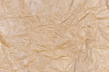 Background of light brown crumpled wrapping paper, fragment, texture
