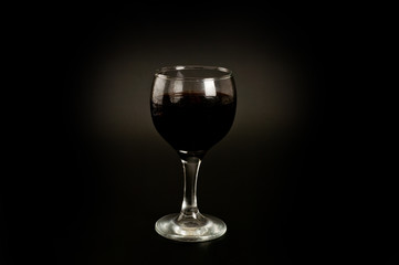 Glass with red wine shot on a dark background. Background for alcohol. Glassware for alcoholic beverages.
