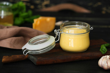Jar of tasty sauce on dark table