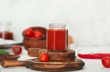 Jar of tomato sauce on white table