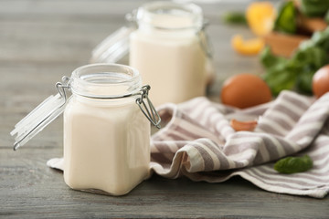 Jar of tasty sauce on wooden table