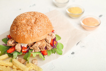 Tasty doner kebab in bun and french fries on white background
