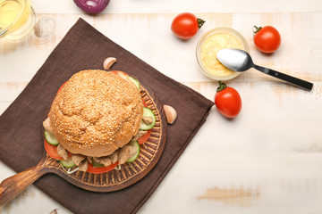 Tasty doner kebab in bun with sauce on table