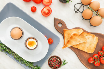 Boiled eggs with toasted bread on white background