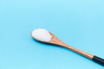 Salt in the wooden spoon on the table