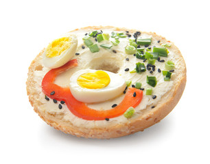Fresh bun with tasty cream cheese, eggs and vegetables on white background