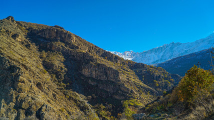 a view of mountains covered with snow in the fall season in  the north of Iraq Kurdistan Region with green landscape and trees in the foreground