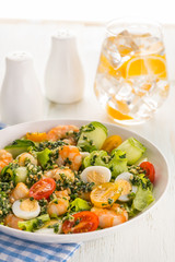 Salad with grilled shrimps, fresh lettuce, cucumbers, cherry tomatoes and quail eggs with pesto sauce.