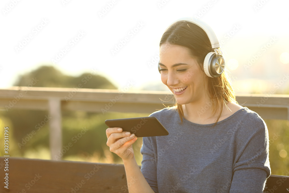 Sticker happy woman watching videos on her phone at the park