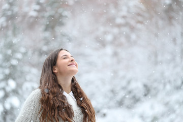 Happy girl enjoying a snowy day in winter