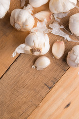 A lot of garlic on a wooden background, top view. Background for design. Vertical photo with space