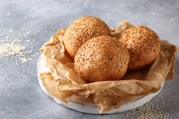 Bakery. Bread with sesame seeds on parchment. On a light grey background. Background image, copy...