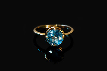 Beautiful old golden ring with blue gemstone isolated on white background