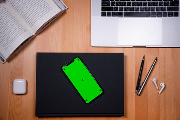 smartphone on a desktop background with a book and a film camera work with a mobile phone, scrolling applications