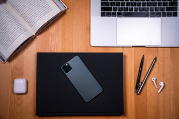 smartphone on a desktop background with a book and a film camera work with a mobile phone, scrolling applications