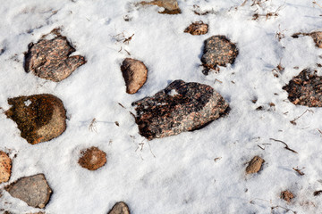 thawed granite stones from under the snow