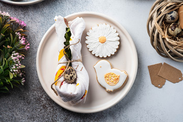 Table setting for the holiday of Easter. The photo shows white dishes, serving mat, Easter egg in a...
