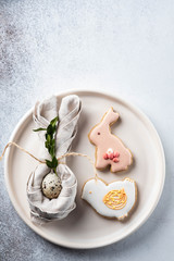 Table setting for the holiday of Easter. The photo shows white dishes, serving mat, Easter egg in a...