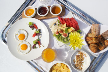 Sunny side up eggs, fresh squizeed orange juice, fruit salad and cereals, healthy organic breakfast option	