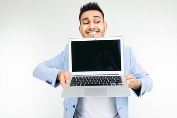 smiling young brunette man holding a laptop screen to the camera with a blank mockup on a white background