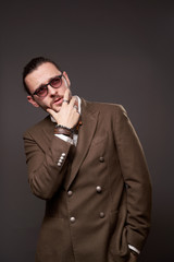 Fototapeta premium Pensive guy with beard in jacket on blank brown background