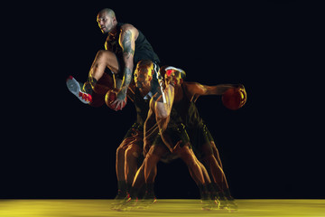 Young basketball player of team in sportwear training, practicing in action, motion isolated on...