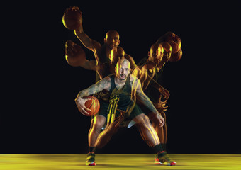 Young basketball player of team in sportwear training, practicing in action, motion isolated on...
